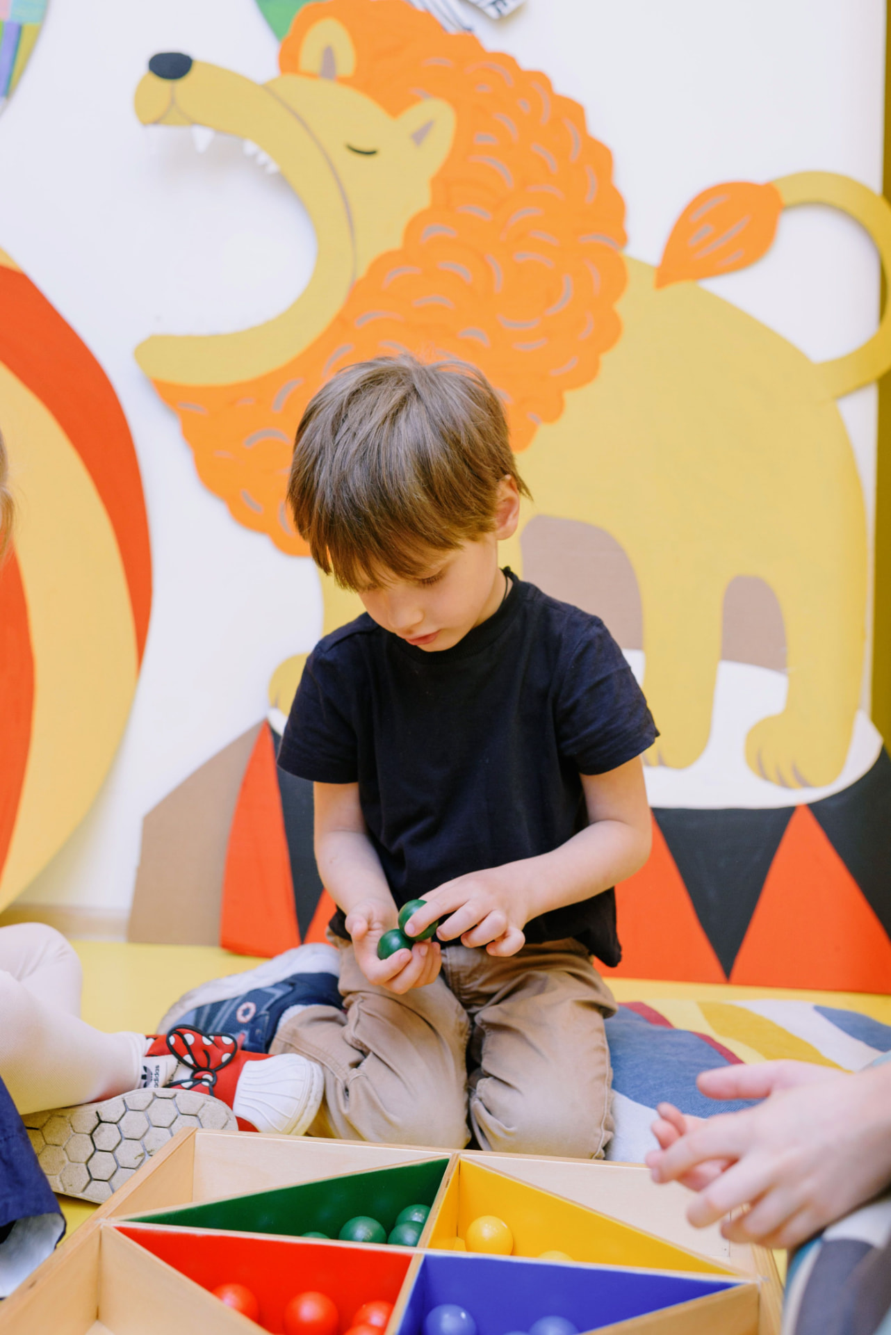 Enfant manipulant un matériel d'inspiration Montessori dans une structure d'accueil